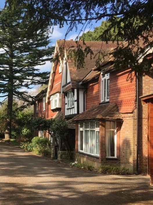 The front of the International College of Oriental Medicine in East Grinstead. An old 18th century cottage with front garden and trees.